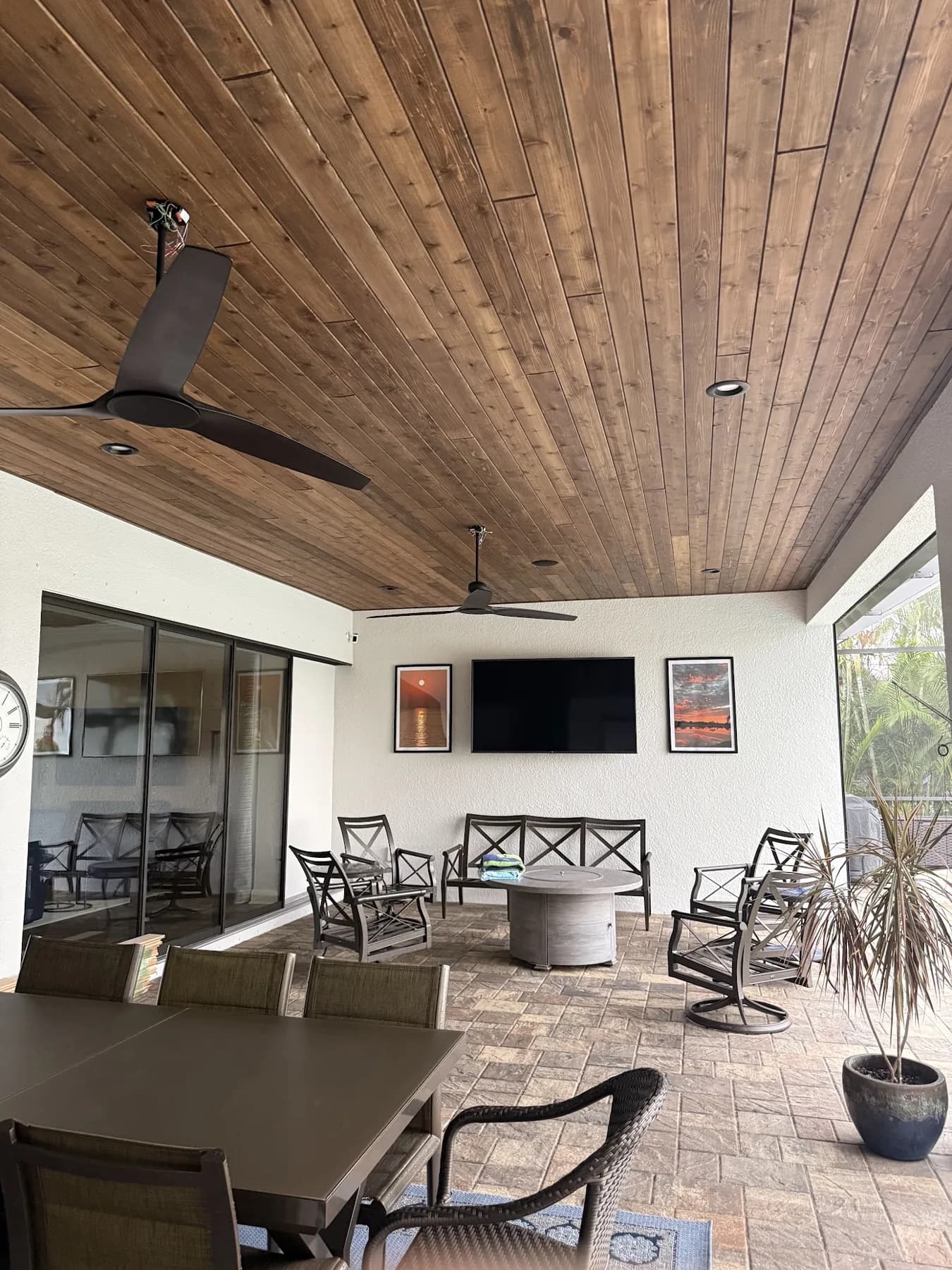 Second view of the cedar lanai ceiling showing varied grain and staggered board ends above black fans