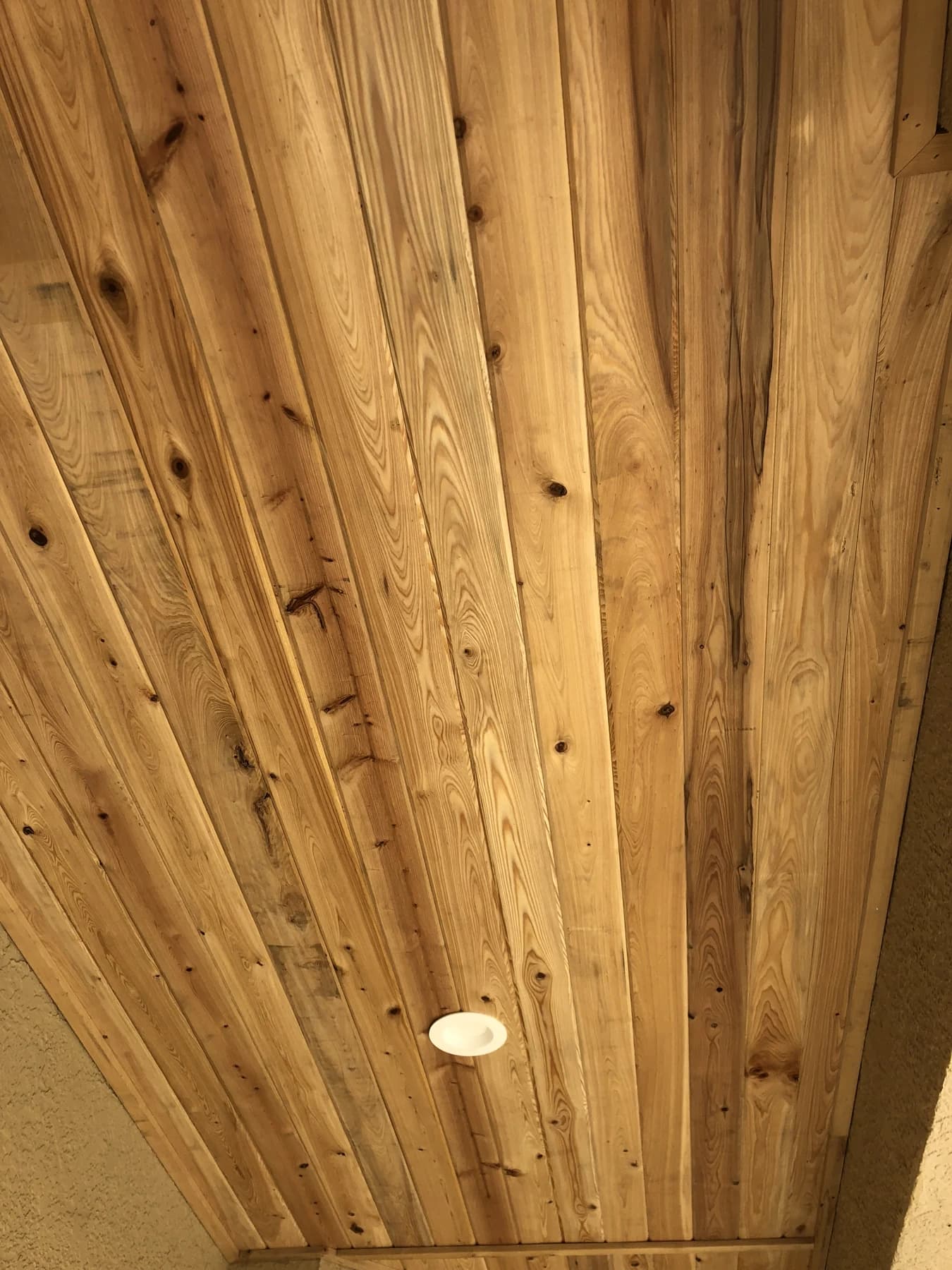 Closer view of the compact patio cedar ceiling at a round light and long perimeter trim