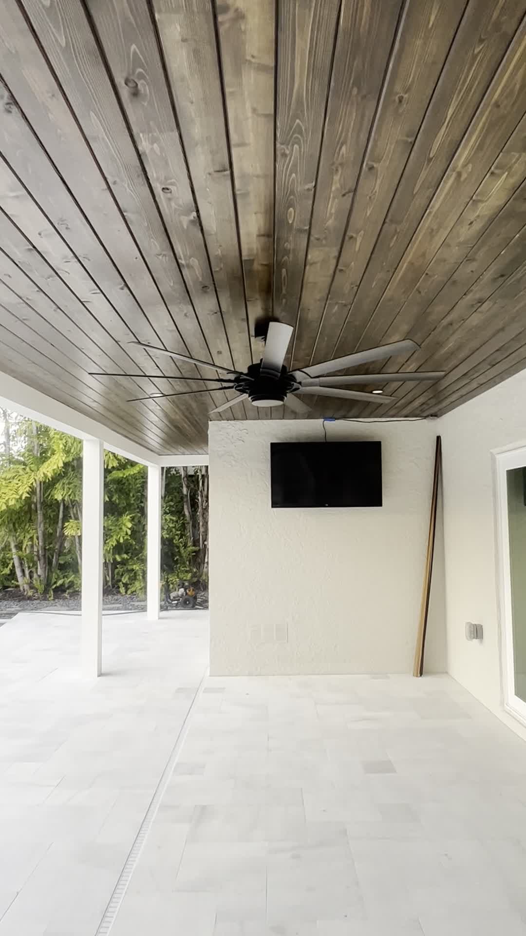 Alternate view of the dark cedar ceiling near its black fan and recessed lights