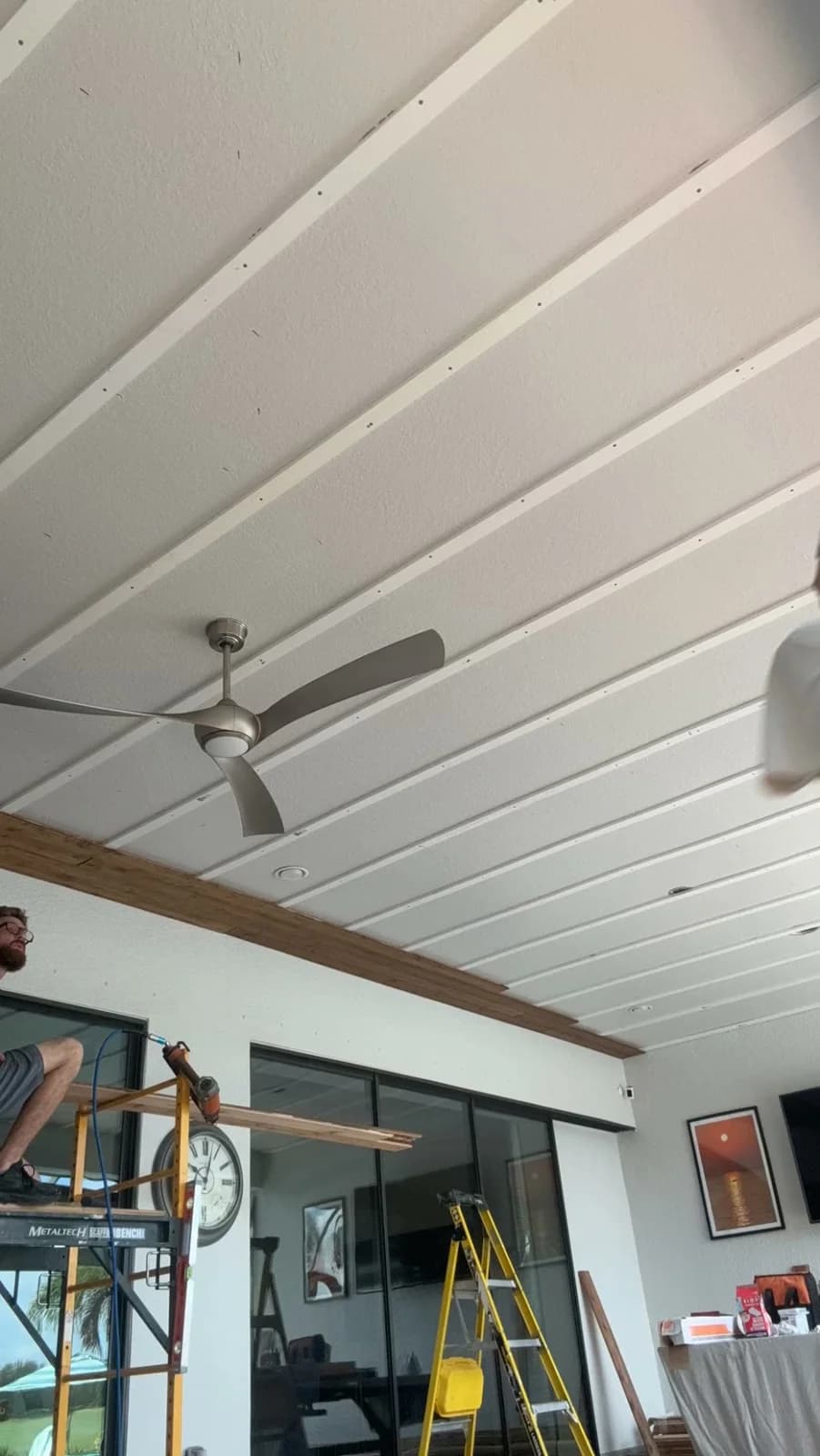 Furring strips over the existing drywall ceiling with the first cedar boards installed along the edge